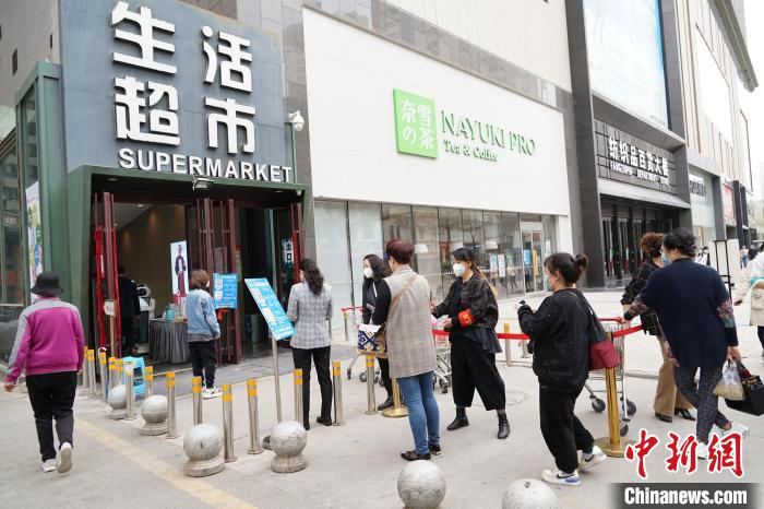 图为西宁市民排队,有序进入超市购物。 马铭言 摄