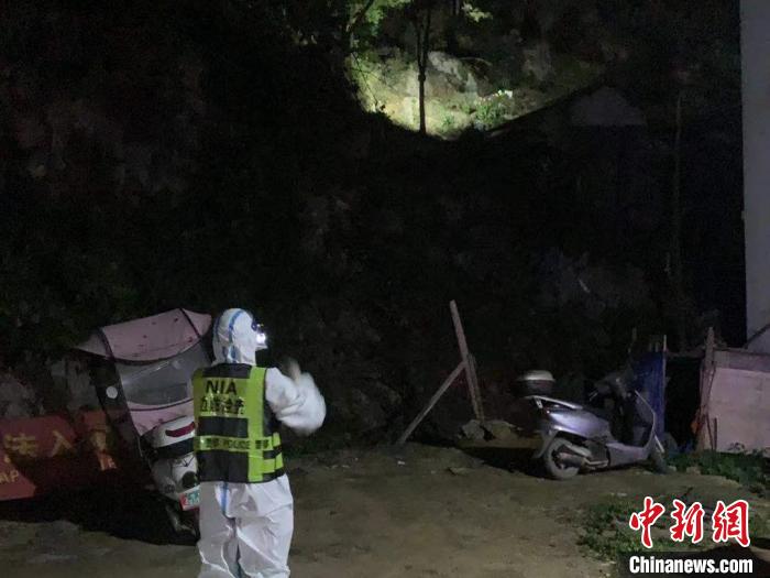 移民管理警察用手电筒照射巡视山坳。 韦德富 摄