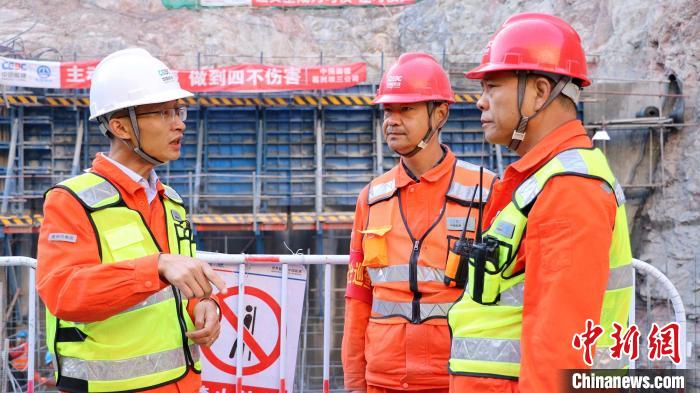 李东飞(左一)在大石峡项目现场与技术人员交流。 王小军 摄