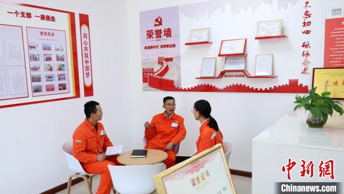 李东飞(中)和年轻员工交流谈心。