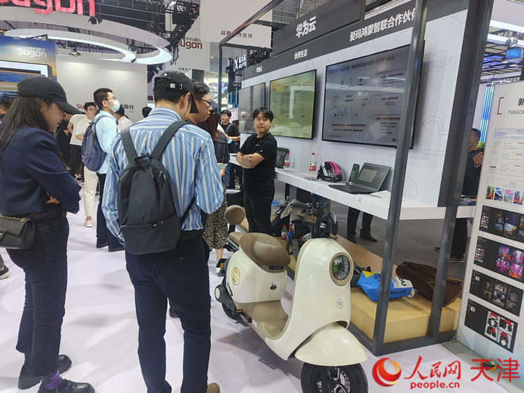 会场上,几位参观者驻足在爱玛刚刚发布的智能产品前,细细观看。人民网记者 孙翼飞摄