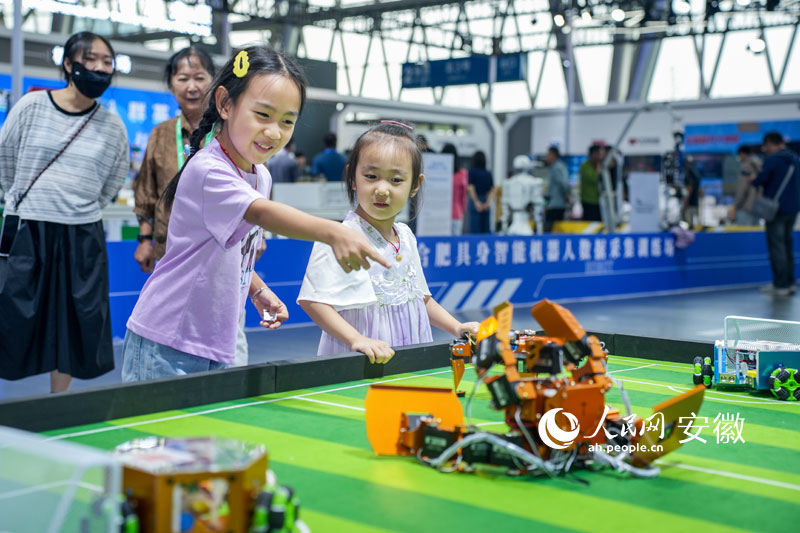小朋友观看机器人足球表演。人民网记者 王锐摄
