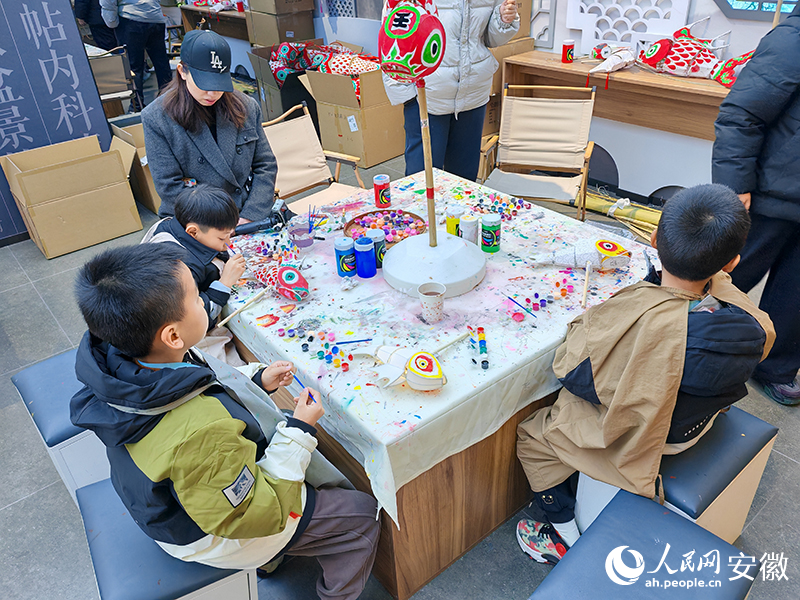 孩子们在绘制心仪的鱼灯。人民网 丁纪摄