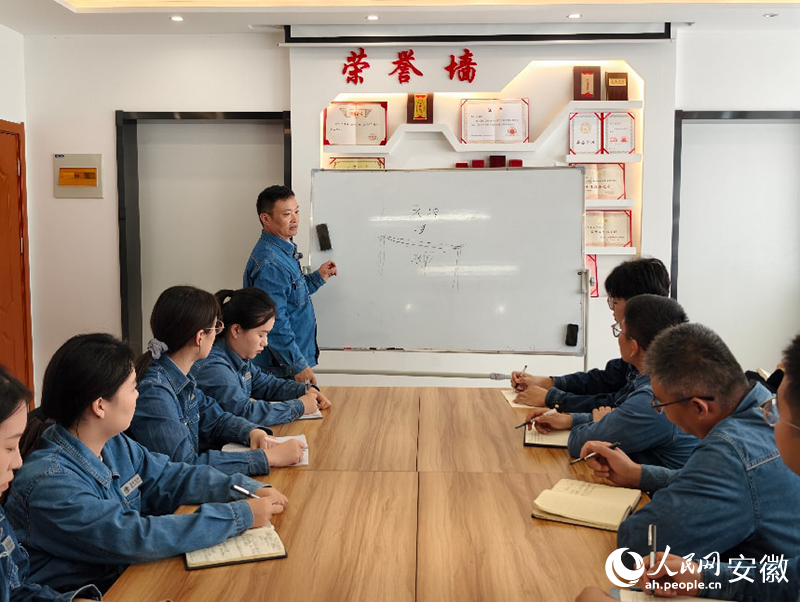 陈石科在向青年员工讲解电力知识。人民网记者 陶伟摄